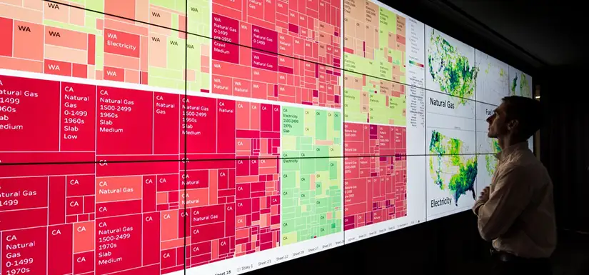 Person looks at analysis and United States maps on large display screen.