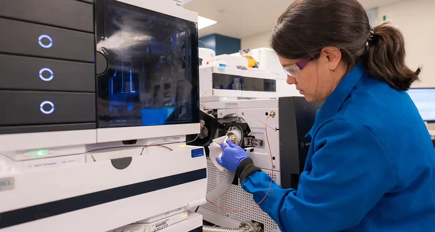 A research technologist cleans the mass spectometer source used for quantification of small molecules.