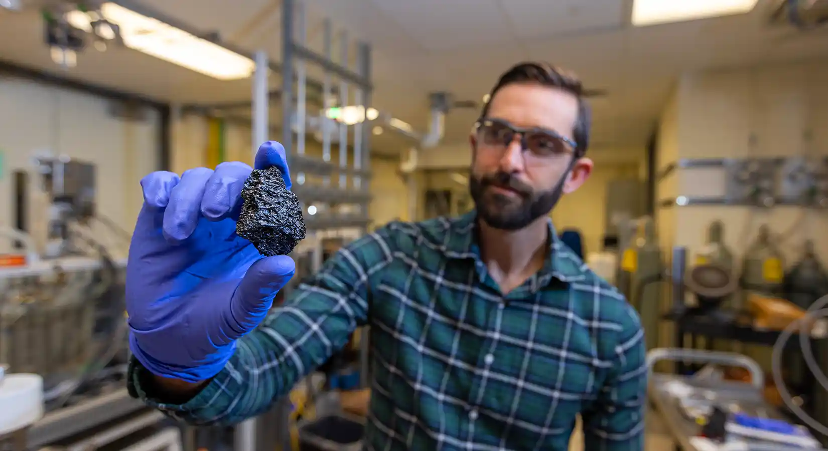 Researcher holds up a sample of bio-coke.