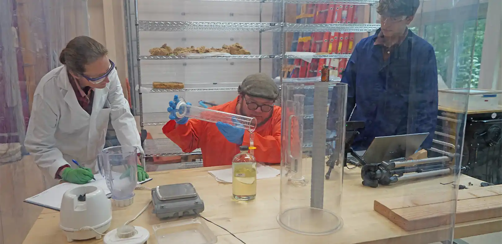 Three researchers growing insulation inside a lab.