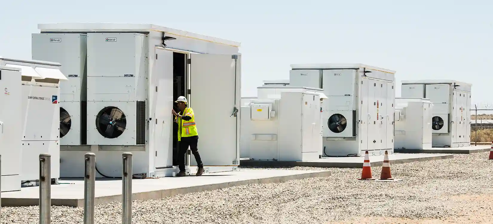 050688-hero Worker looking in energy security storage unit outside.