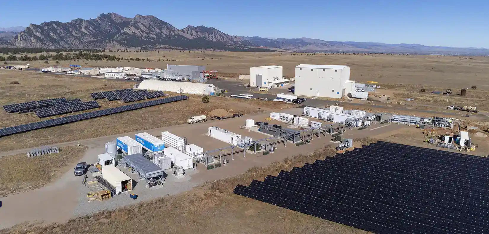 Aerial view of NREL's campus with energy storage buildings and solar arrays.