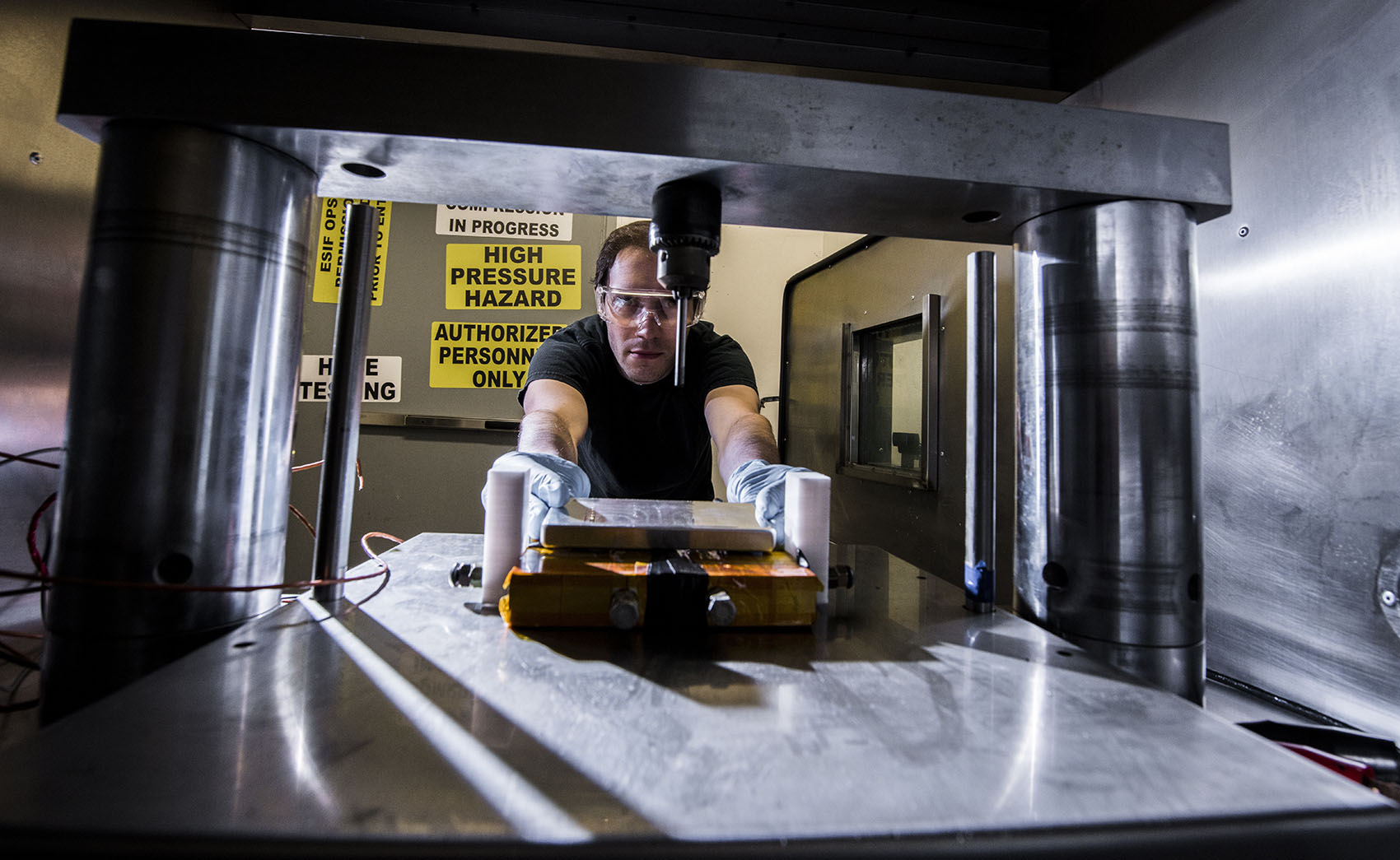 A person placing a battery into a metal chamber.