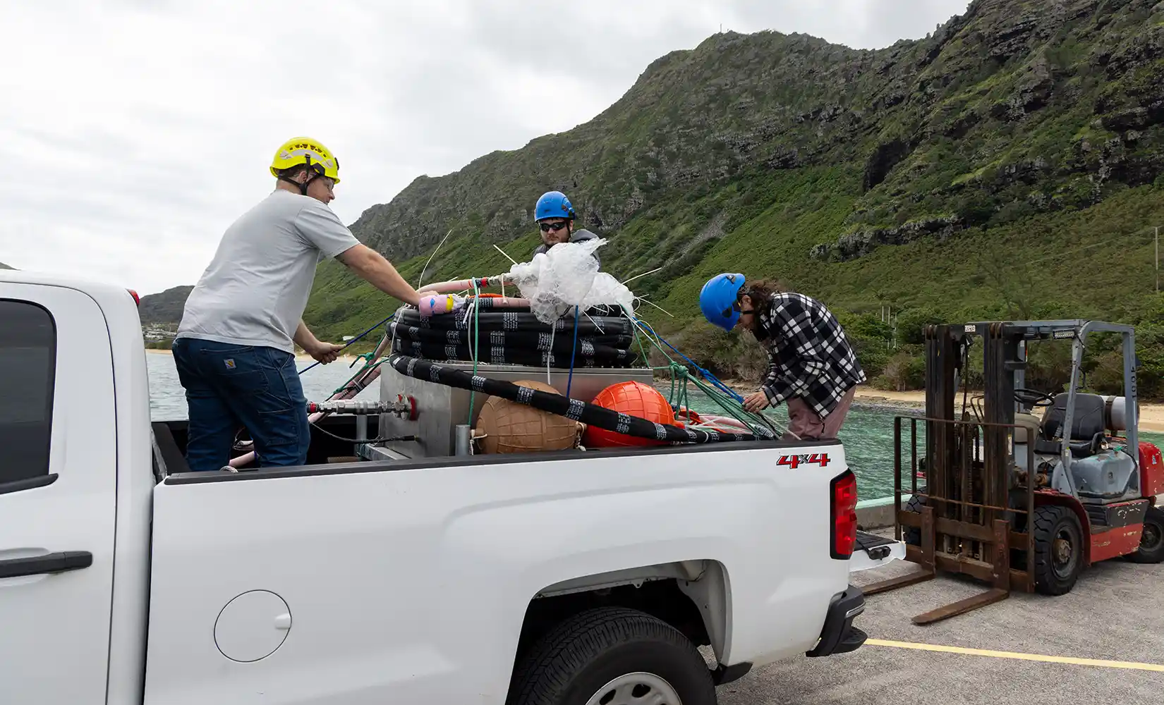 Researcher unloading the SURF-WEC's power takeoff system enclosure from a truck.
