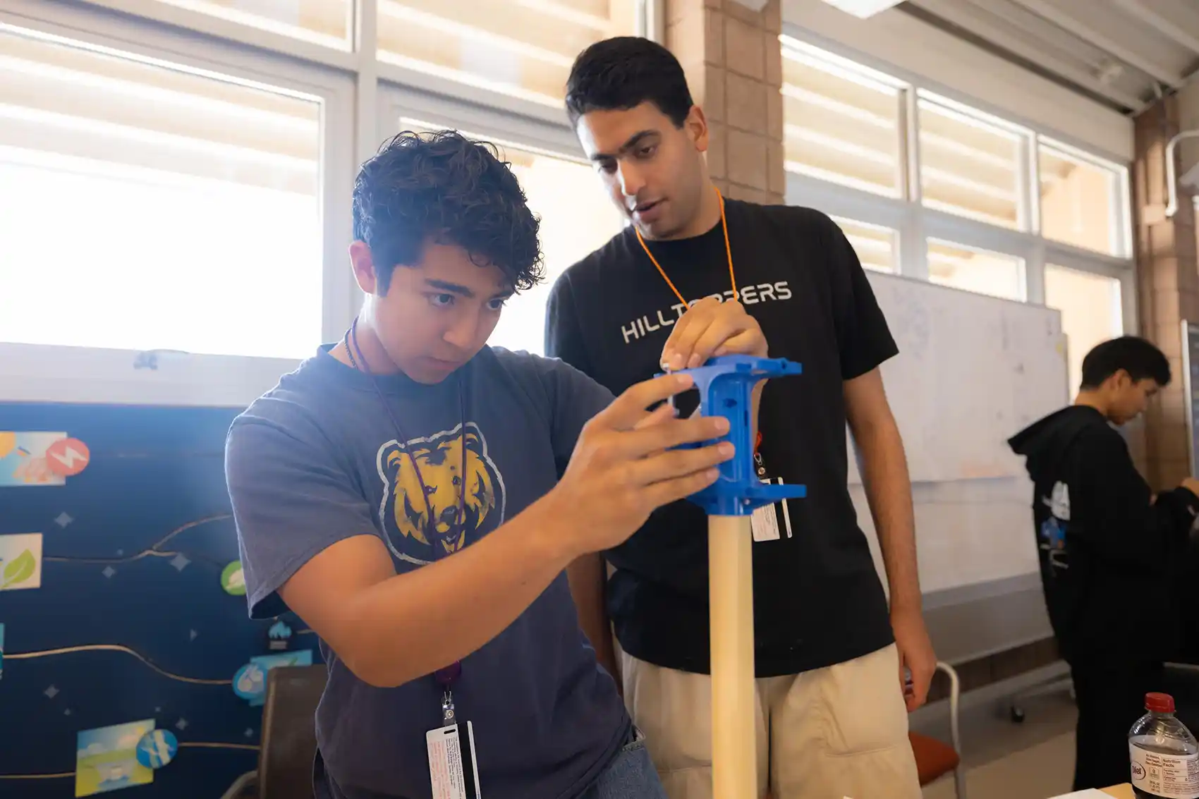Two people examine a tool.