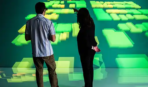 Continue reading about Two people stand in front of a 3D visualization screen on a wall.