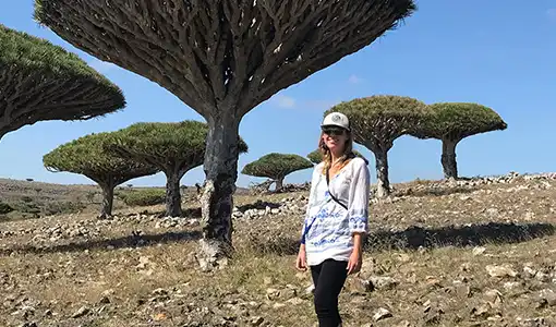 Continue reading about Kristi Moriarty stands in front of funnel-shaped trees.