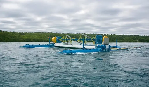 Photo of RivGen power system floating on the surface of a river with trees in the background.