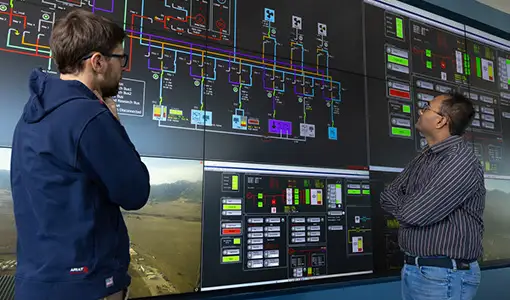 Continue reading about Two people look at graphics on a large screen.