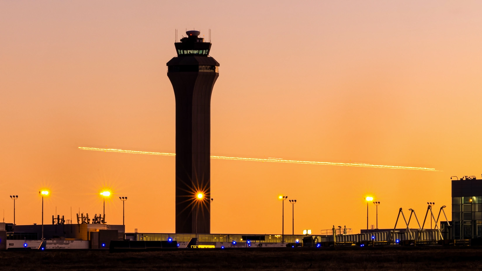 An airport air traffic control tower at sunset