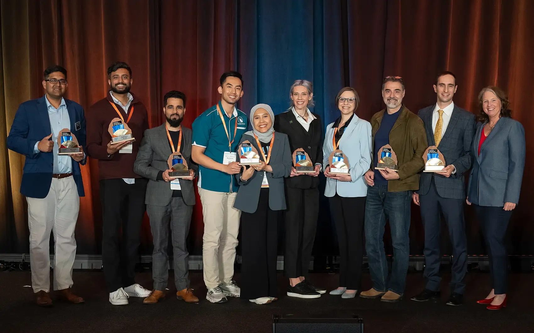 20260413-2026-industry-growth-forum-all-systems-go-as-advanced-energy-innovation-startups-pitch-to-investors-4609 Ten people holding trophies standing on a stage.