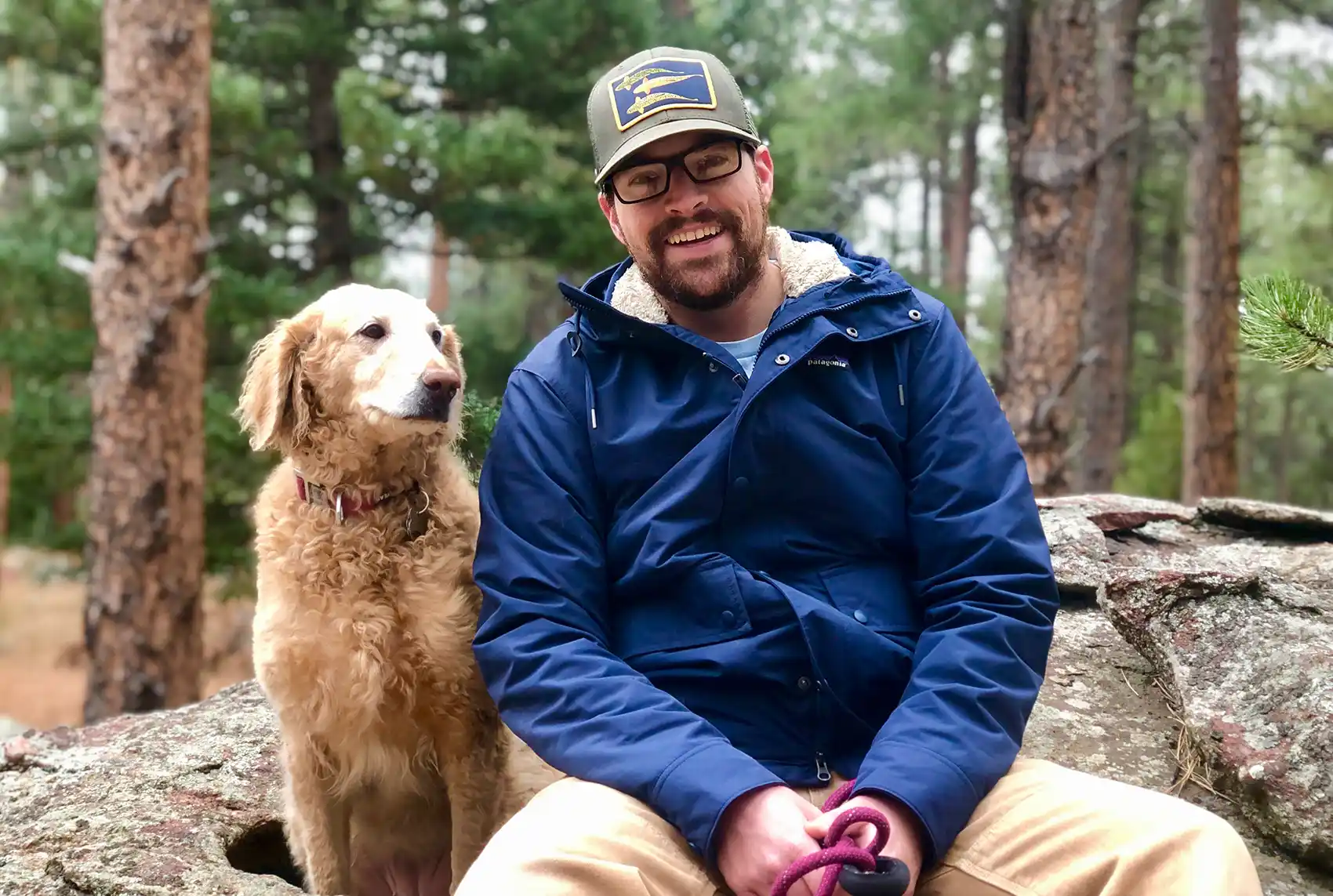 Trevor Martin hiking in the woods with his dog.