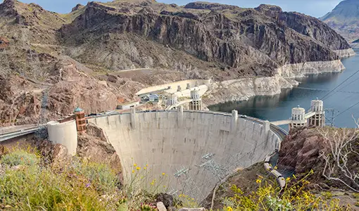 Continue reading about A photo with mountains, water, a dam, and plants.