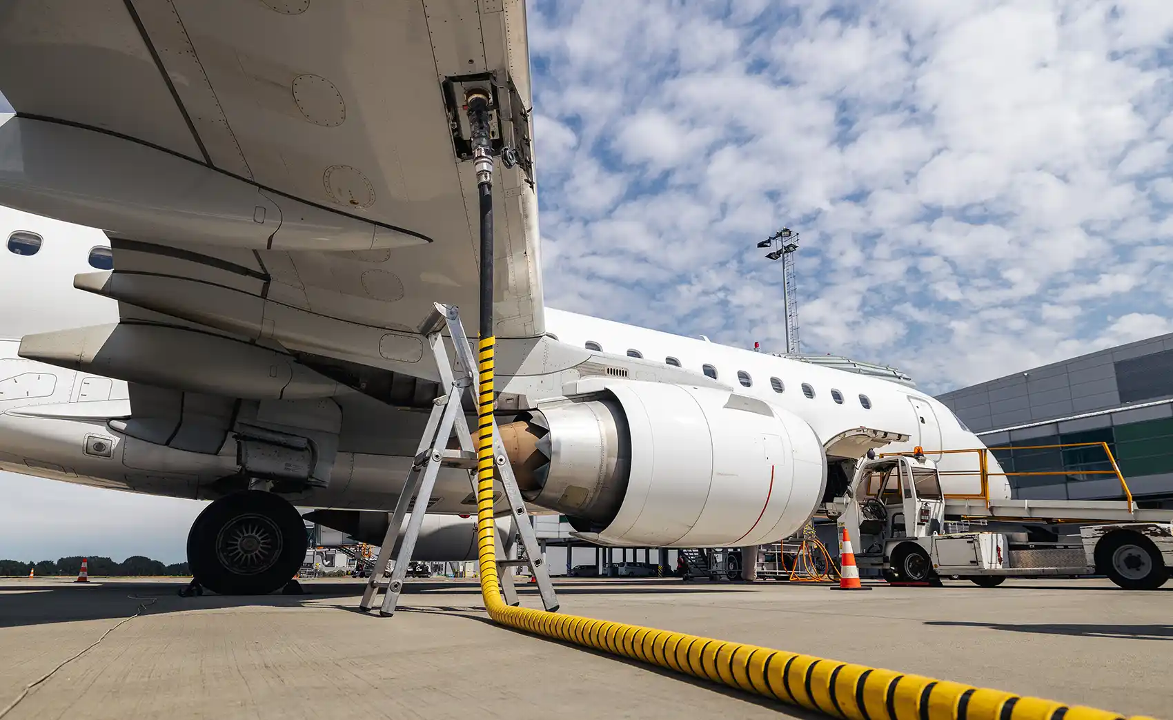 20260723-as-jet-fuel-supplies-tighten-can-other-fuels-meet-demand-getty A parked airplane refuels using an aboveground fuel line.