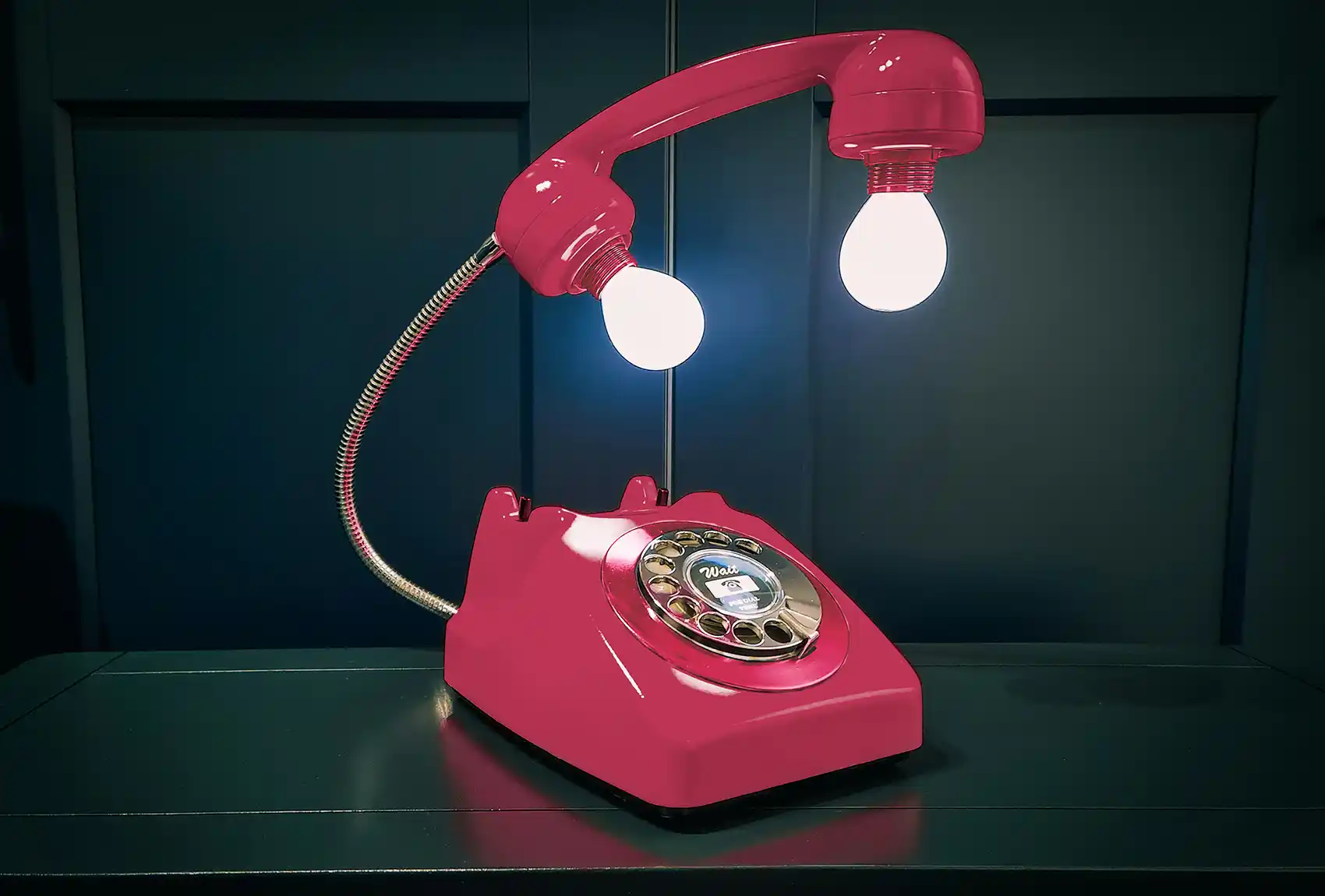 A red rotary phone with light bulbs in the receiver.