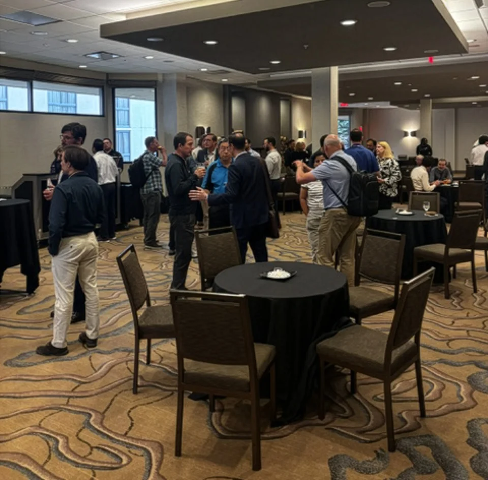 People standing and talking in a large room.