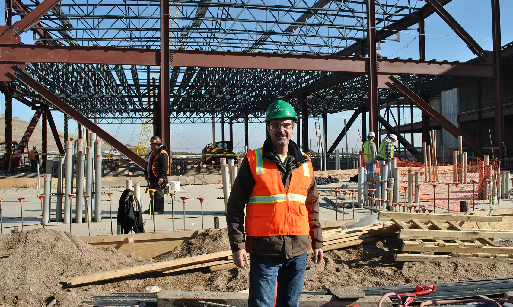 20260824-q-and-a-with-steve-hammond-ai-data-center-challenges-and-nlr-solutions-esif A person in a construction vest and hard hat standing in front of a construction site.