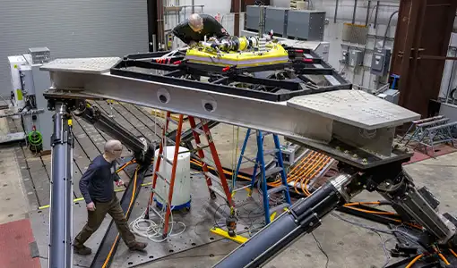 The large-amplitude motion platform with two people working on it.