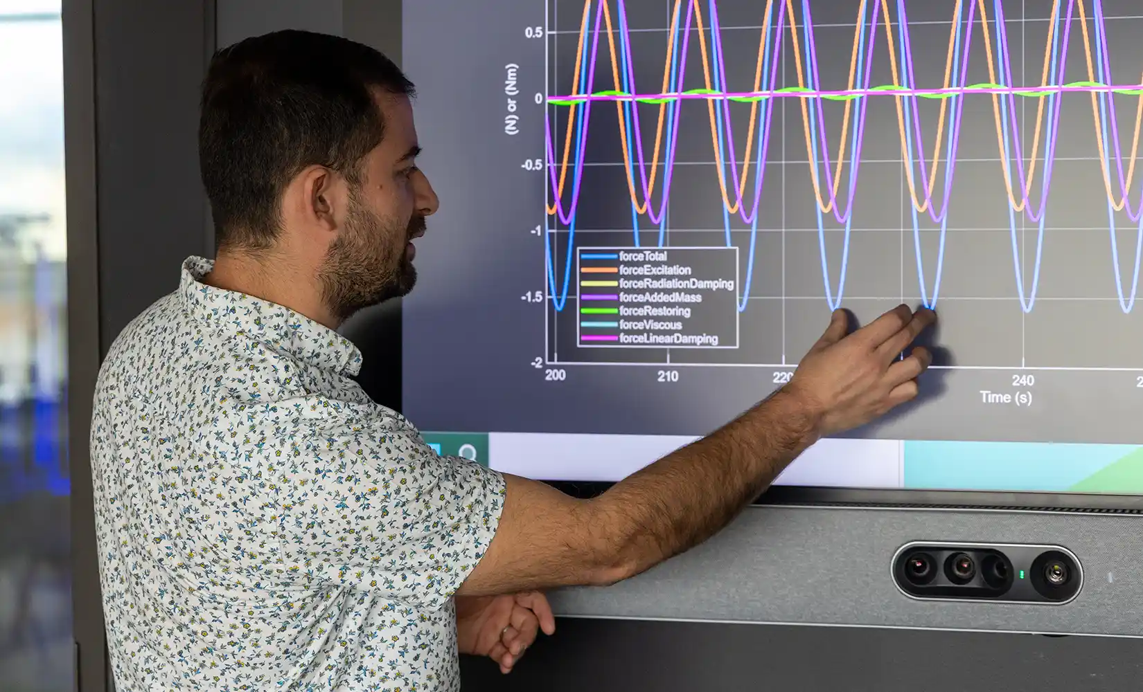 Researcher looking at a charge on a large computer screen.